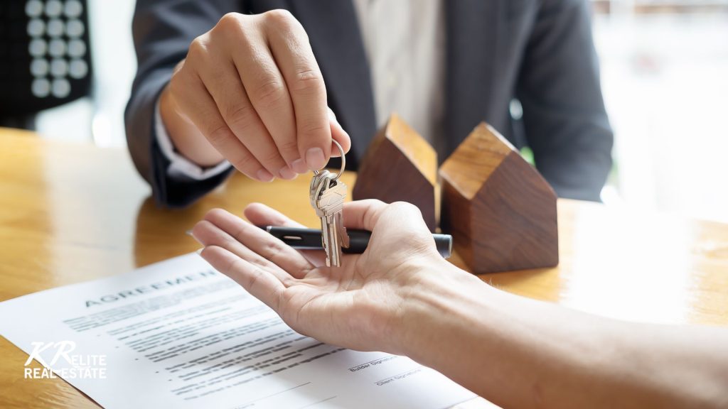 a person handing over keys to another person