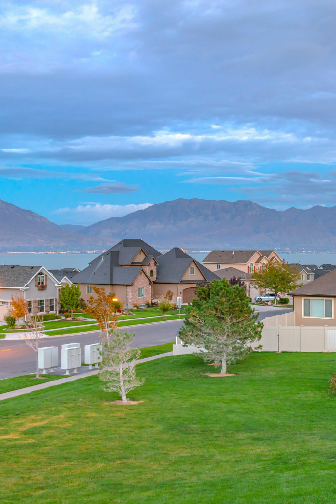 a neighborhood with a body of water and mountains in the background