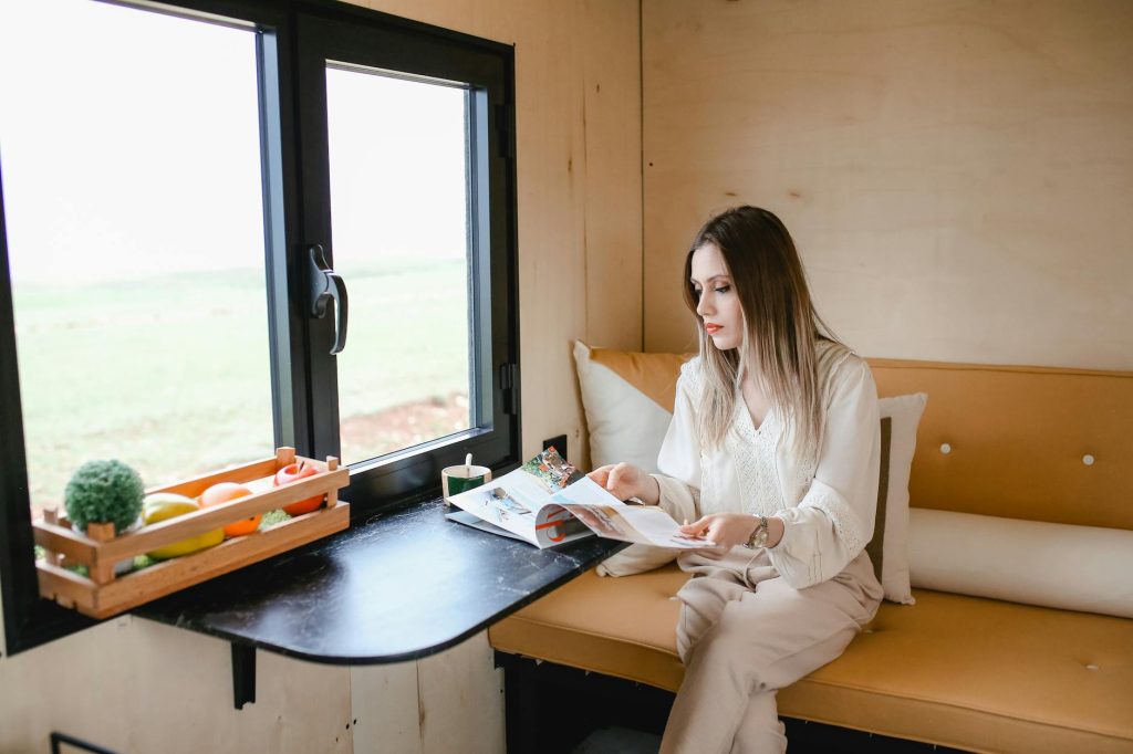 Woman Sitting and Looking Through a Magazine 